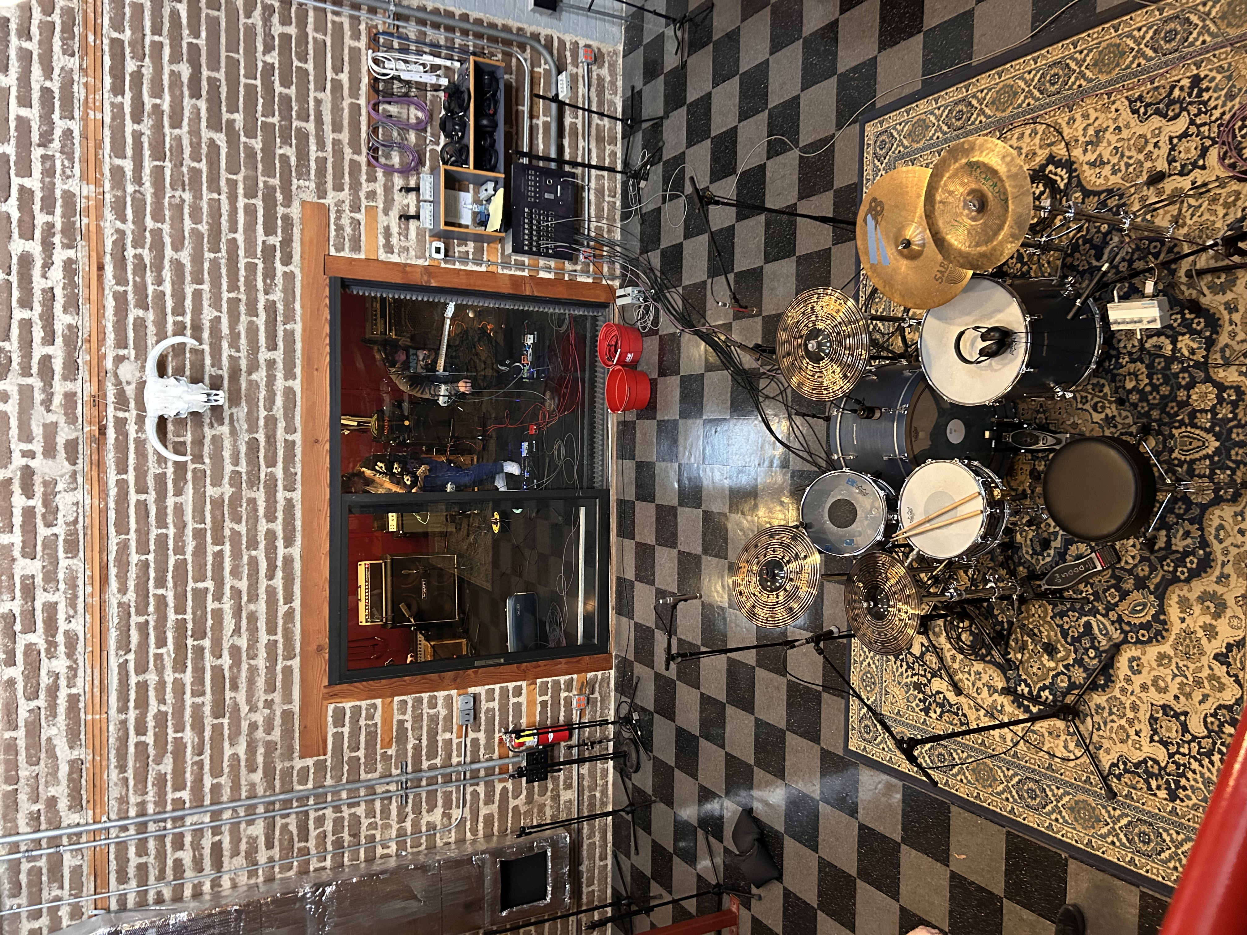Studio session overhead view with drum kit and control room window